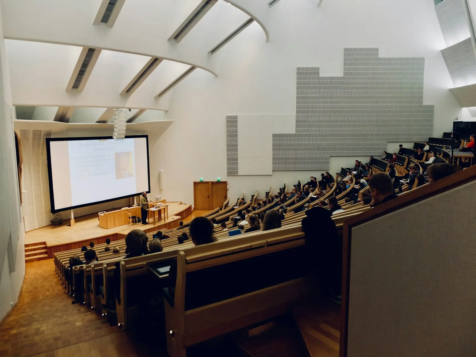 A modern university lecture hall with students attending a presentation